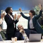 Joyful pleased colleagues celebrating project achievement