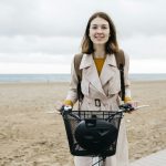 Portrait of smiling woman with e-bike at the beach