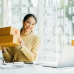 Portrait young attractive asia female owner startup business work happy with box at home prepare