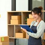 Small businesses owner in apron working at drop shipping business office.