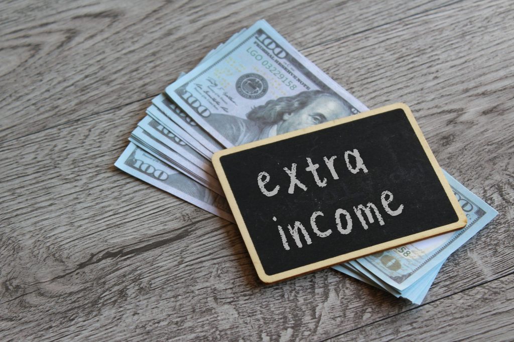 Top view image of money and chalkboard with text EXTRA MONEY.