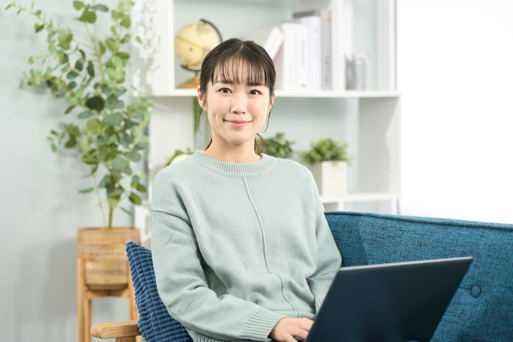 A woman operating a laptop in the living room