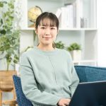 A woman operating a laptop in the living room