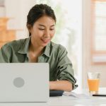 Asian women records of income and expenses at home.