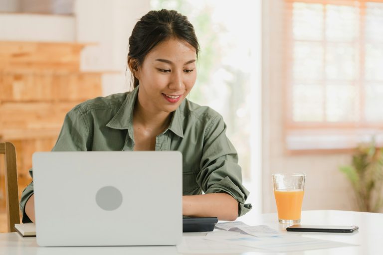 Asian women records of income and expenses at home.