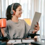Bussiness woman sitting on the share at home drinking tea from an orange cup.