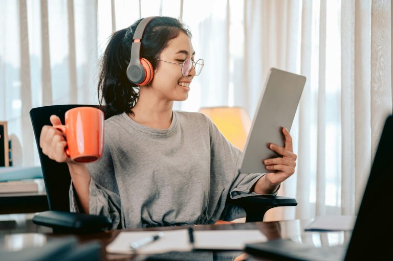 Bussiness woman sitting on the share at home drinking tea from an orange cup.
