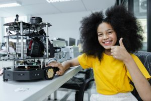 Girl with afro hairstyle thumbs up education electronic on table at class room.