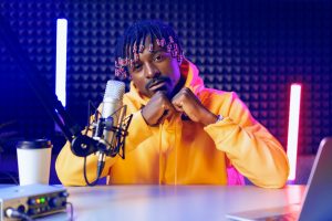 Happy young african man audio blogger broadcasting at studio