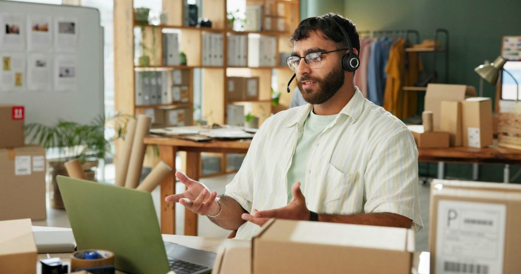 Man, call center and talking on laptop for delivery, cargo or track shipping on online shopping hel