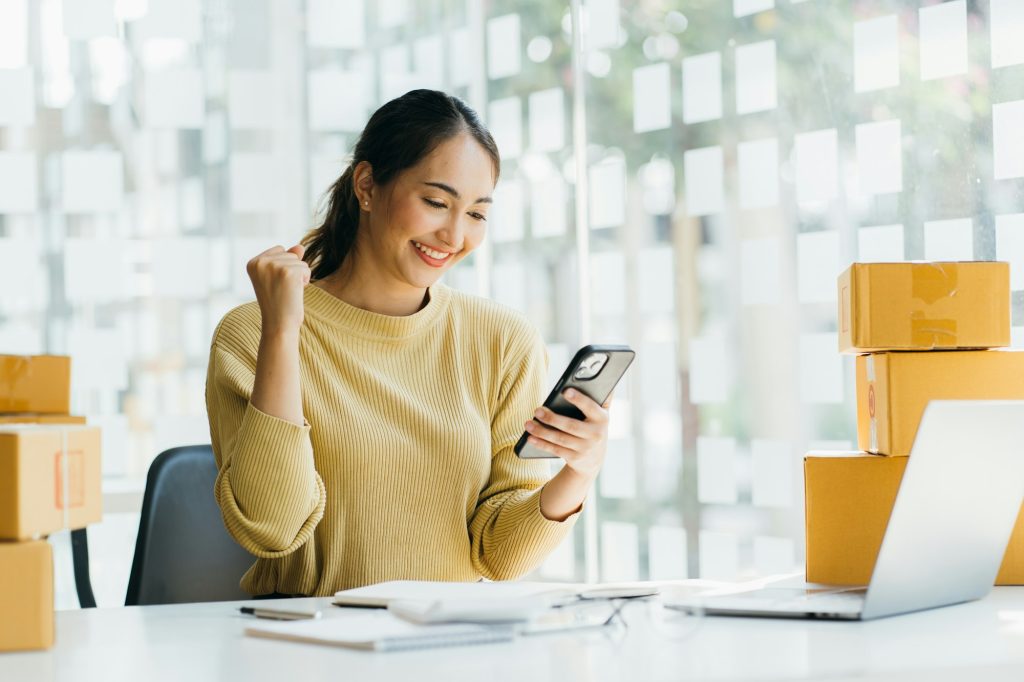 Portrait young attractive asia female owner startup business work happy with box at home prepare