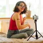 Woman blogger videotapes her vlog at home and speaking about Vaccine for covid-19.