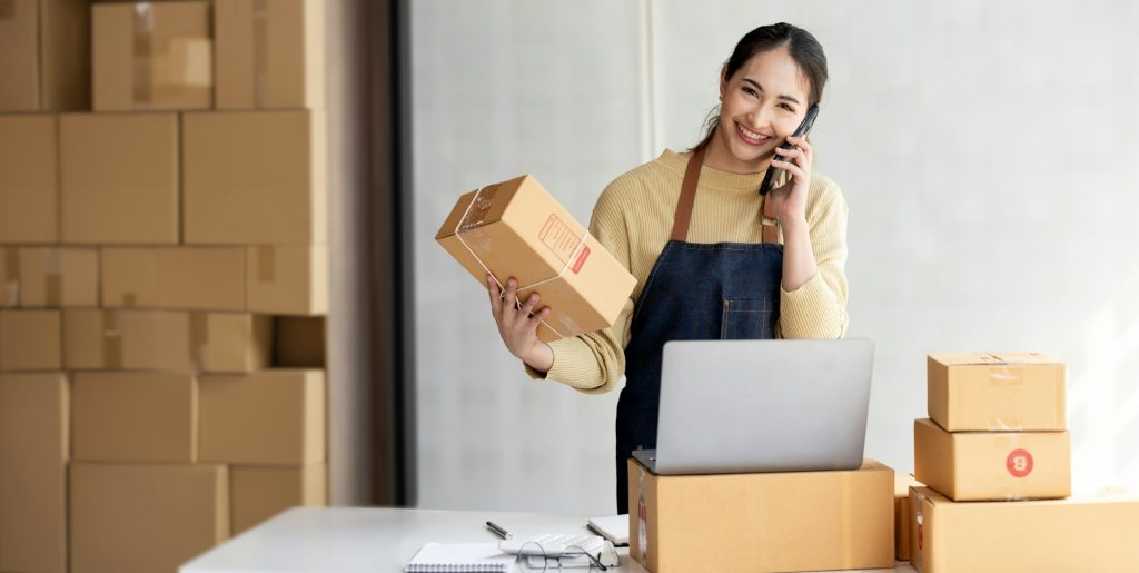 Female entrepreneur working at home office confirming the order on phone.