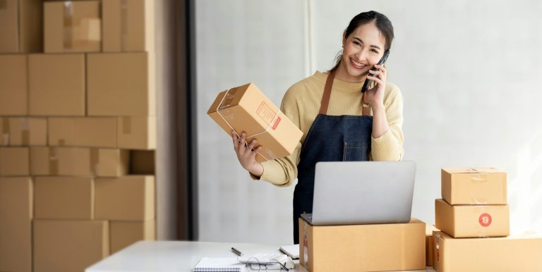 Female entrepreneur working at home office confirming the order on phone.