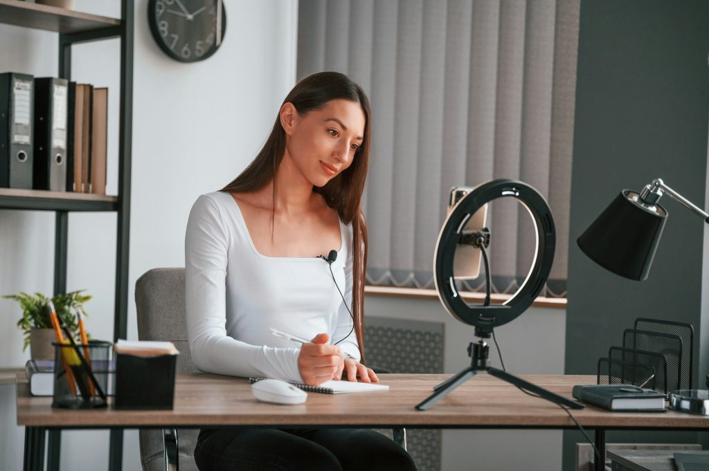 Online education. Young beautiful woman in white clothes is in the office