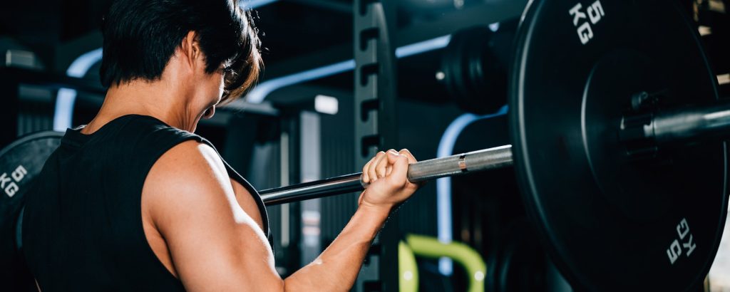 A determined bodybuilder lifting heavy barbells in the gym