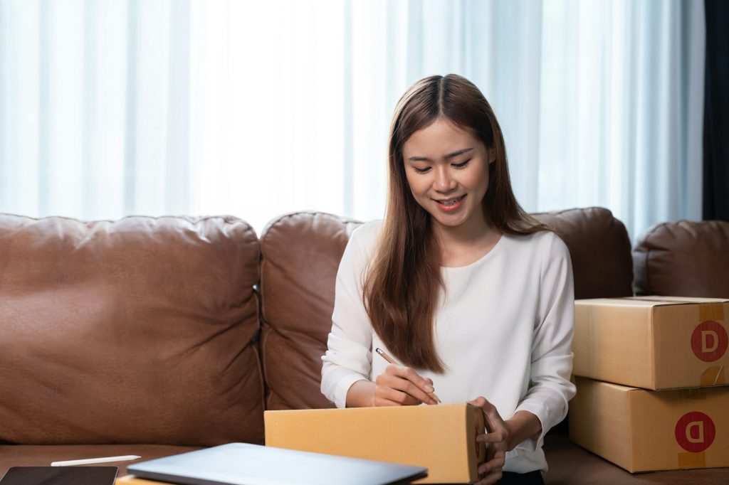 Asian female online store small business owner entrepreneur seller packing shipping ecommerce box