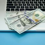 Close up, dollar bills on laptop, money making concept.