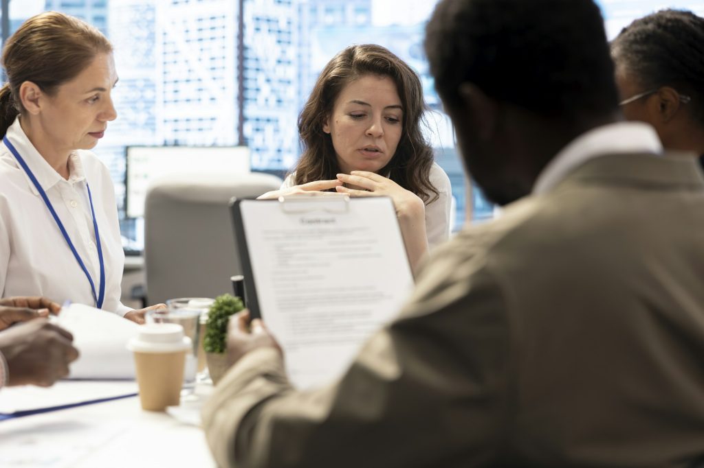 Diverse team of business people meeting in boardroom to examine annual records