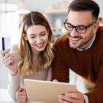 Happy smiling couple shopping online at home. Technology, e-commerce concept