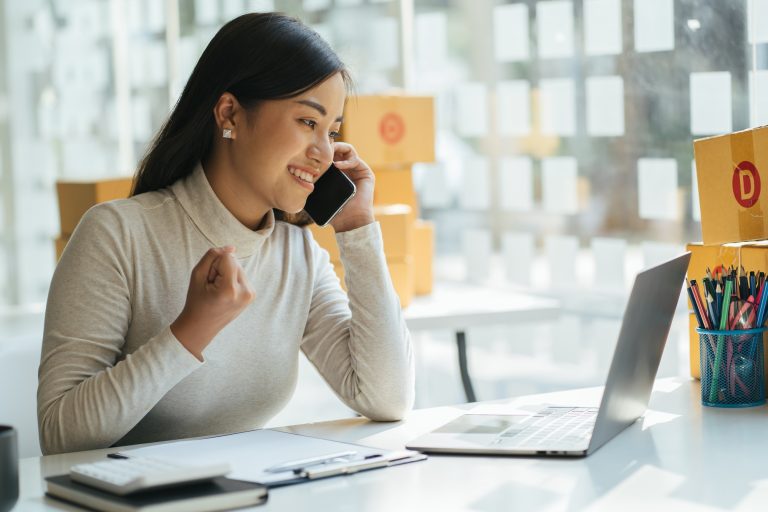 Portrait young attractive asia female owner startup business look at camera work happy with box at