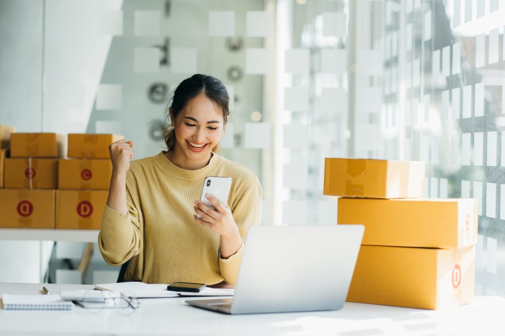 Portrait young attractive asia female owner startup business work happy with box at home prepare