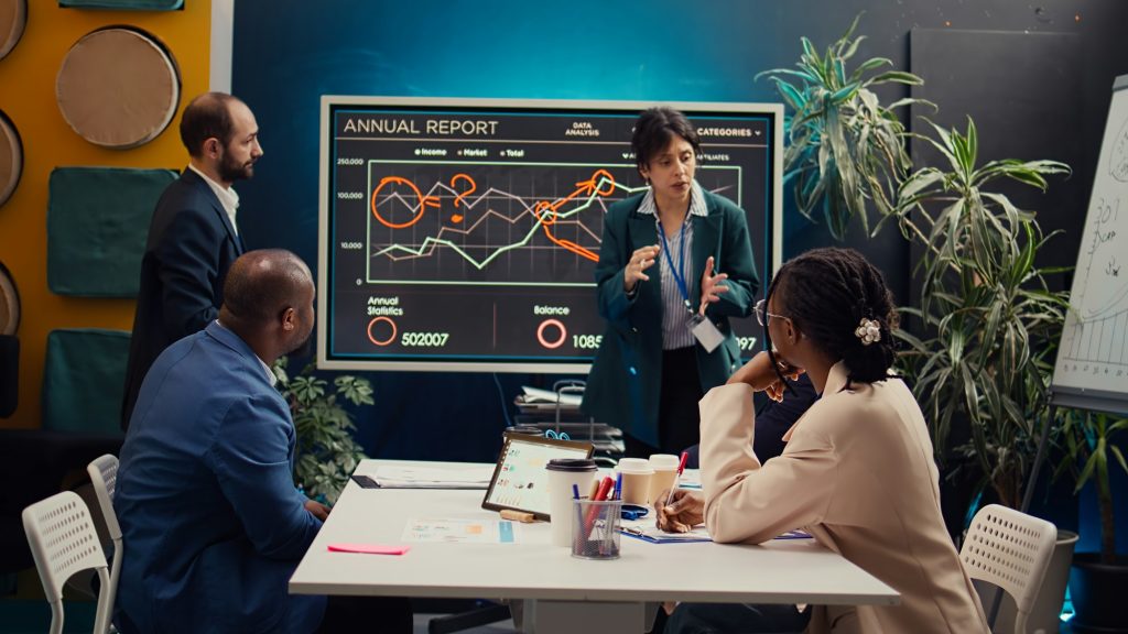 Skilled project team reviewing annual reports market trends in briefing meeting