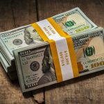 Stacks of 100 dollars banknotes bundles