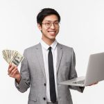 Waist-up portrait of successful rich asian businessman, IT programmer selling application or his